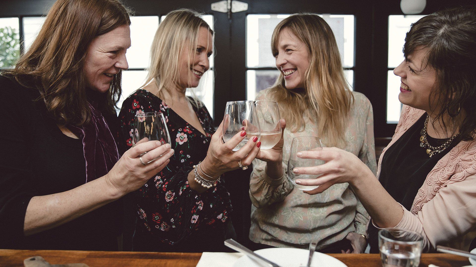 4 females toasting in a restaurant